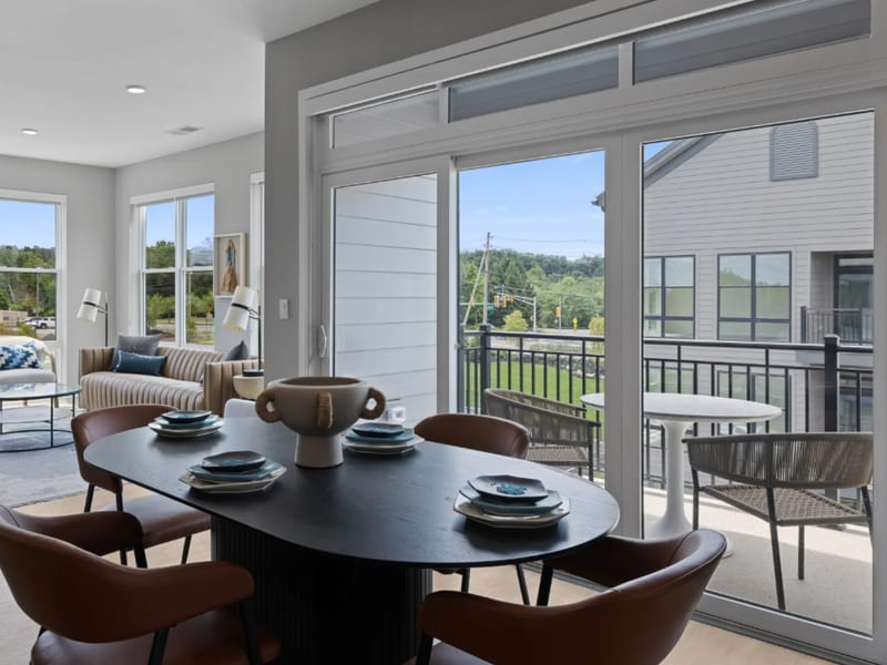 A white sliding patio door beside a dining table, opening onto a deck