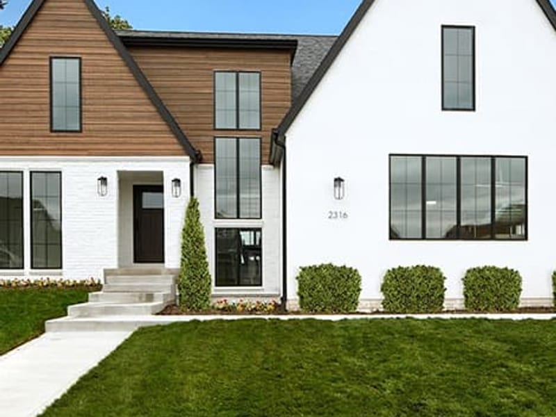 Black-framed windows across a white render and stained timber gable elevation