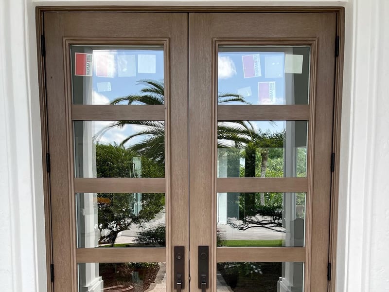 A pair of wood-finish entry doors with full-height glazing
